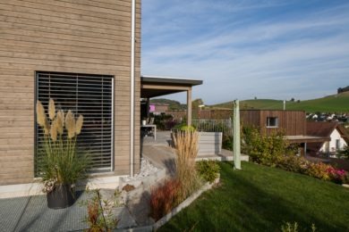 Beiges Holzhaus mit Garten- Holzbau - Holzhaus - Holzsystembau - PM Mangold